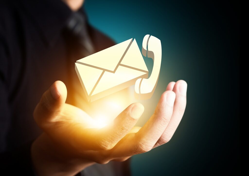 Symbolische Darstellung von Kontaktmöglichkeiten: Telefon und E-Mail in einer Hand.